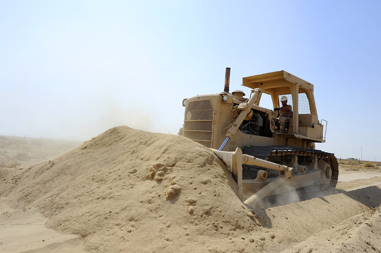 Bulldozer pushing a pile of sand